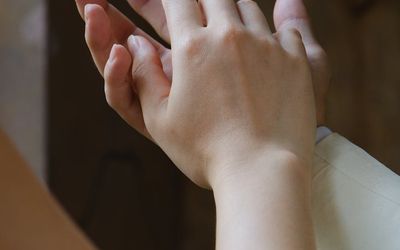 Close-up of hands gently clasped together.